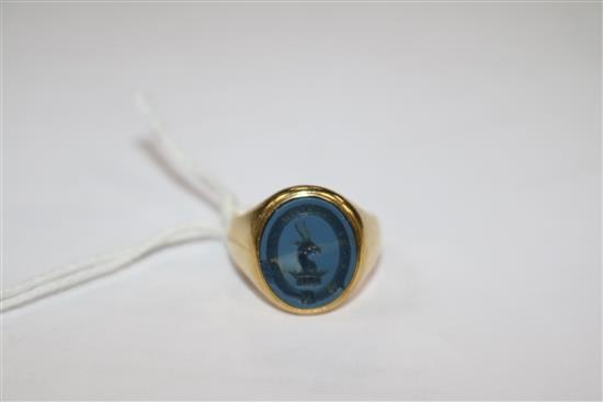 An early 20th century 18ct gold and blue chalcedony signet ring, carved with crested matrix, size L.